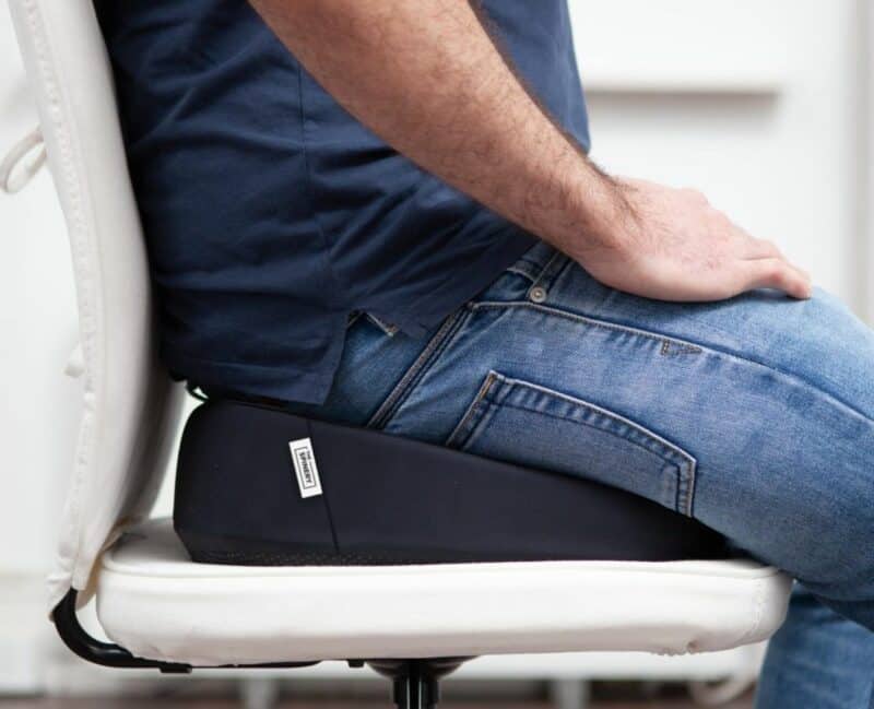 close up picture of a man sitting on ergonomic seat wedge