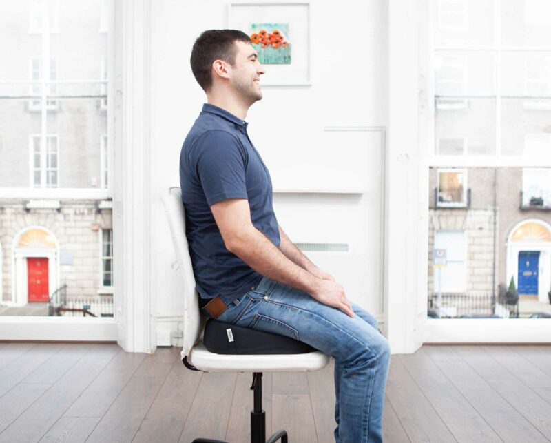 Man sitting on a ergonomic seat cushion in a Dublin, Ireland office building