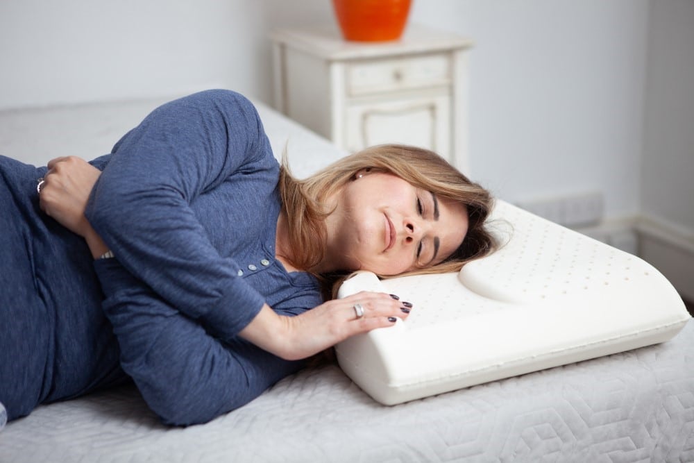 woman lying sideways on a pillow designed for reducing wrinkles