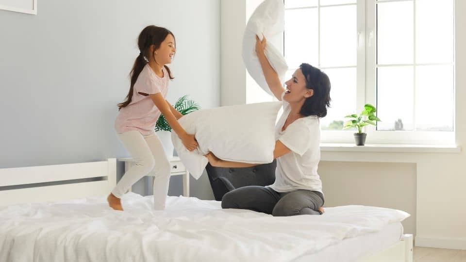 женщина и дочь играют на ортопедическом матрасе с подушками