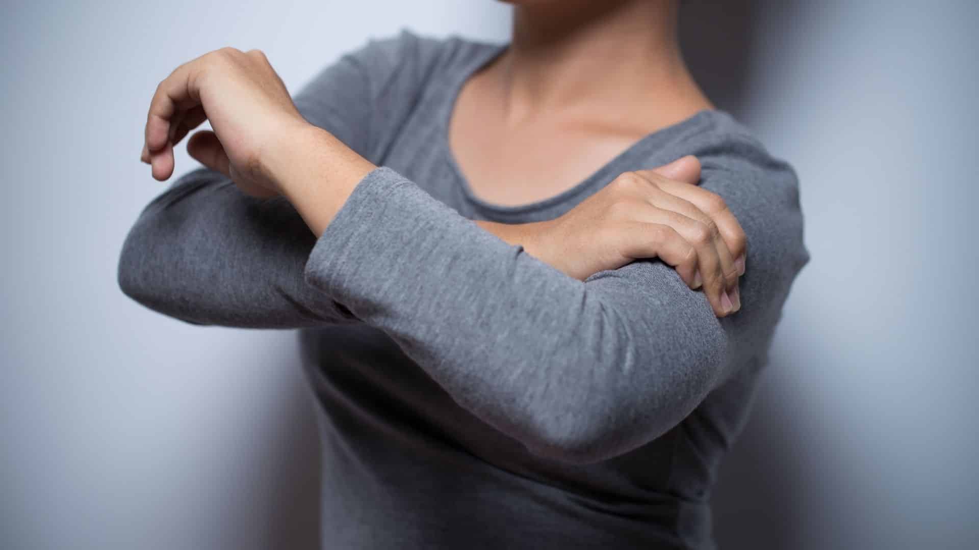 Woman suffering from Pins and Needles in her arm