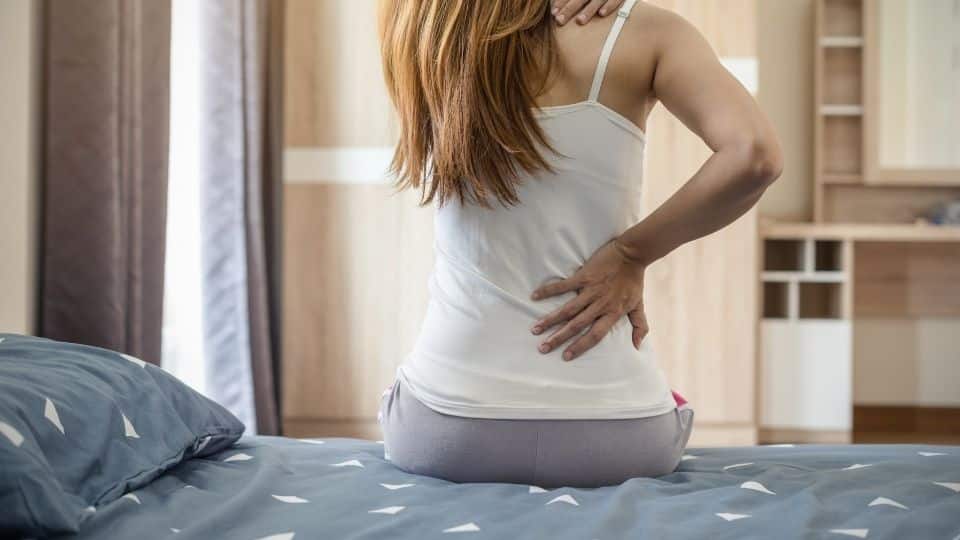 woman suffering from lower back pain from a firm mattress